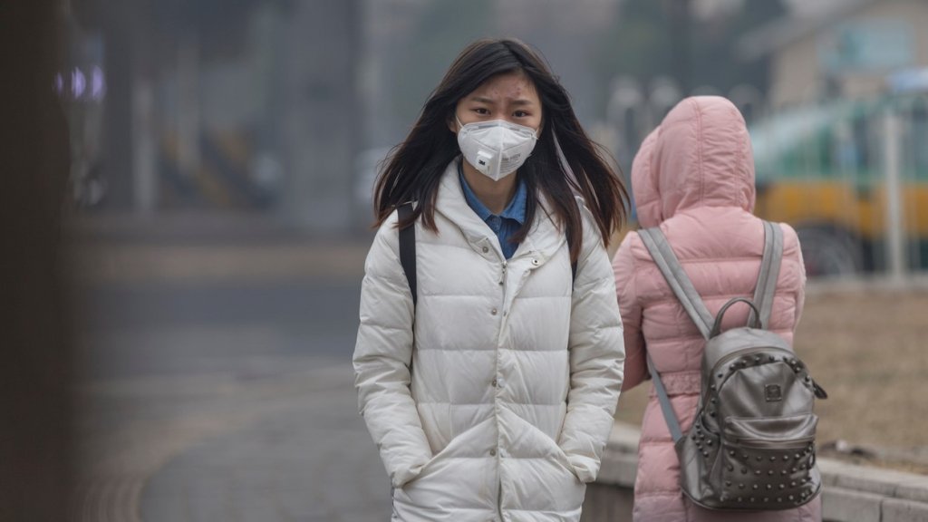 Girl wearing mouth mask with filter against air pollution, Beijing