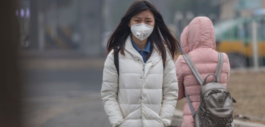 Girl wearing mouth mask with filter against air pollution, Beijing