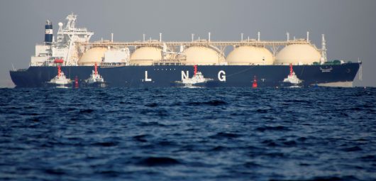 An LNG tanker is tugged towards a thermal power station in Futtsu